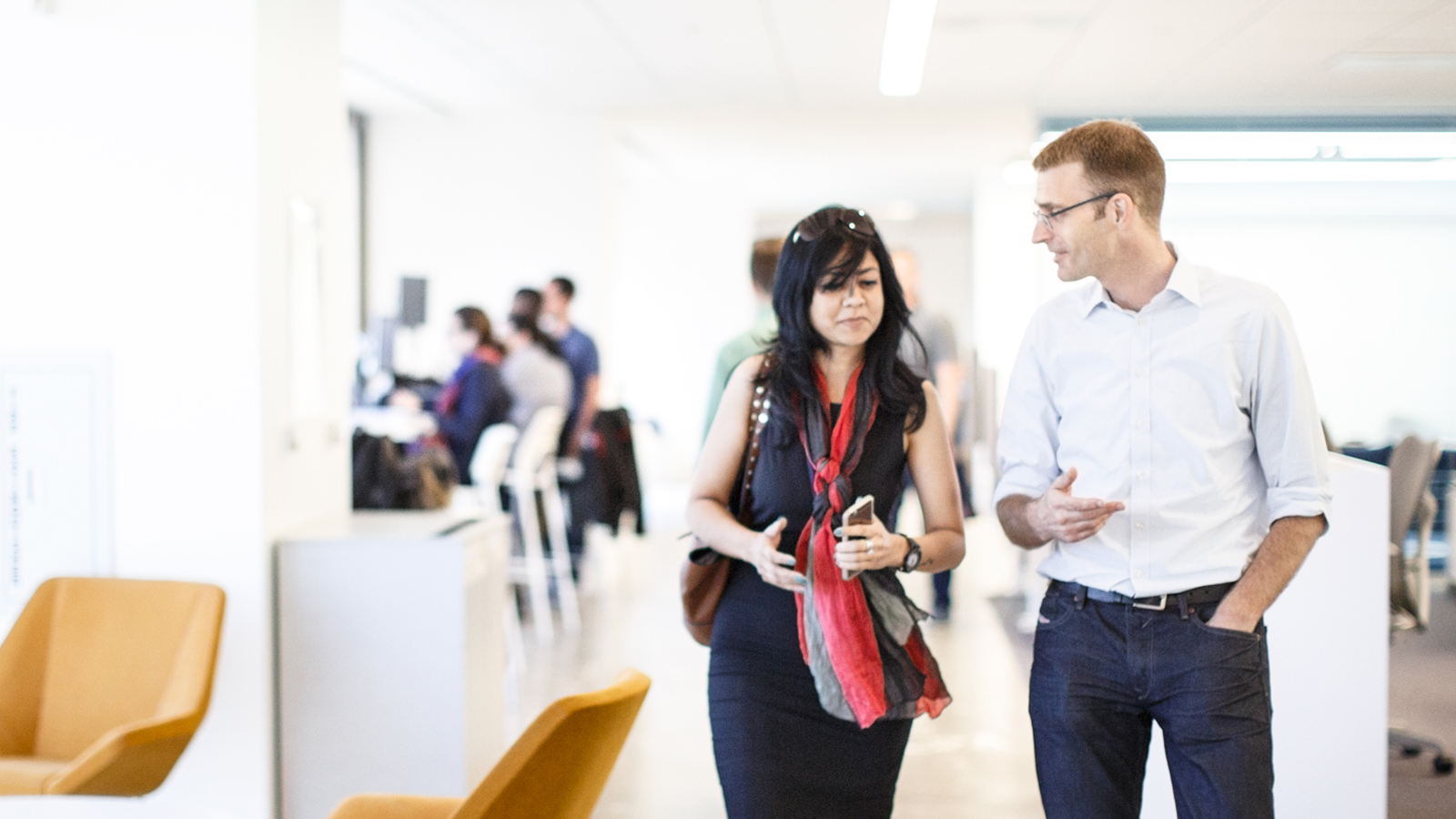 Man and woman walking together through a building and talking. 