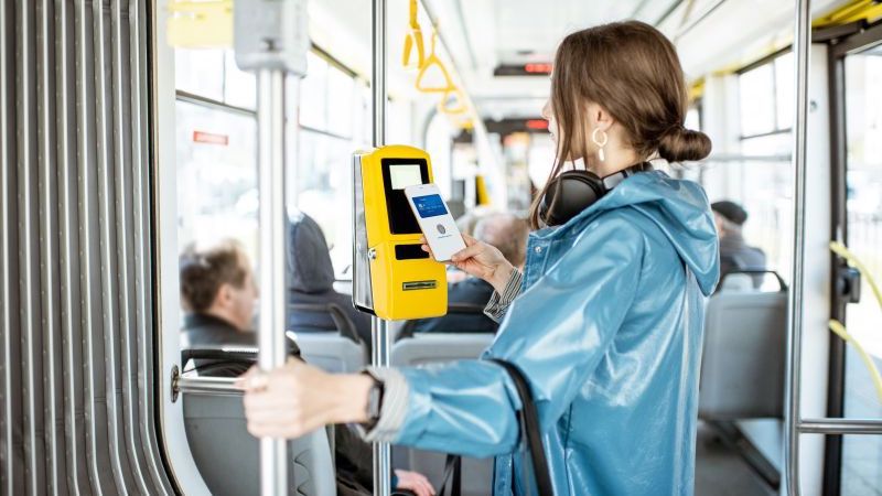 woman making tap to pay payment on bus